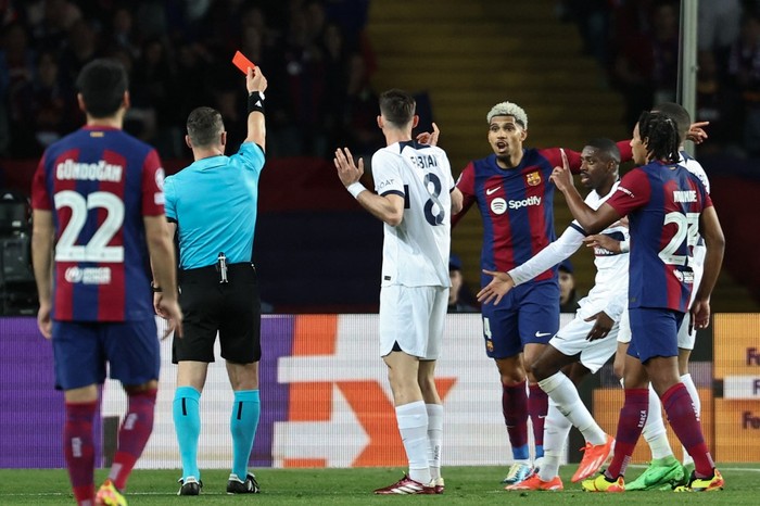 FBL-EUR-C1-BARCELONA-PSG Romanian referee Istvan Kovacs gives a red card to Barcelona's Uruguayan defender #04 Ronald Araujo during the UEFA Champions League quarter-final second leg football match between FC Barcelona and Paris SG at the Estadi Olimpic Lluis Companys in Barcelona on April 16, 2024. (Photo by FRANCK FIFE / AFP)