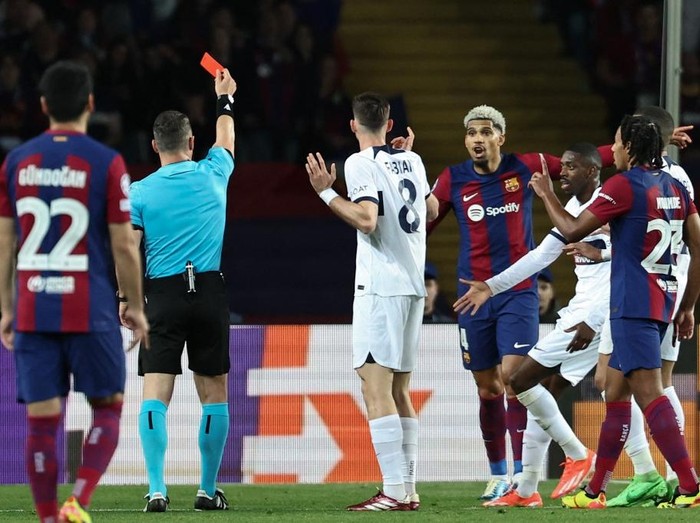 Romanian referee Istvan Kovacs gives a red card to Barcelona's Uruguayan defender #04 Ronald Araujo during the UEFA Champions League quarter-final second leg football match between FC Barcelona and Paris SG at the Estadi Olimpic Lluis Companys in Barcelona on April 16, 2024. (Photo by FRANCK FIFE / AFP)