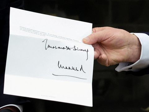 U.S. President Donald Trump holds a letter from Britain's King Charles as he meets with British Prime Minister Keir Starmer in the Oval Office at the White House in Washington, D.C., U.S., February 27, 2025. REUTERS/Kevin Lamarque