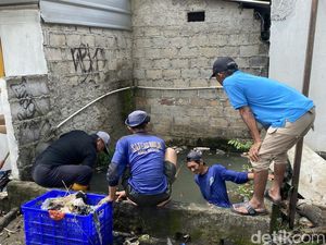 Pasukan Biru Bersihkan Sampah Sisa Banjir di Jalan Margonda Depok