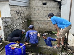 Pasukan Biru Bersihkan Sampah Sisa Banjir di Jalan Margonda Depok