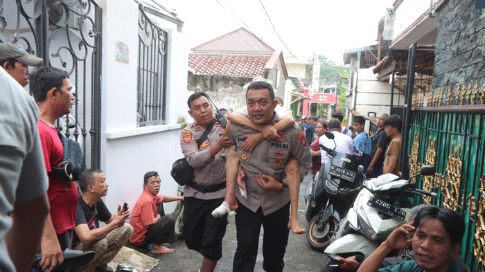 Polisi Gendong Lansia Terjebak Banjir di Cawang
