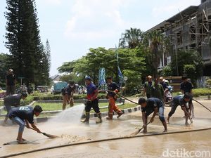 Petugas Damkar-Warga di Bekasi Gotong Royong Bersihkan Jalan dari Lumpur
