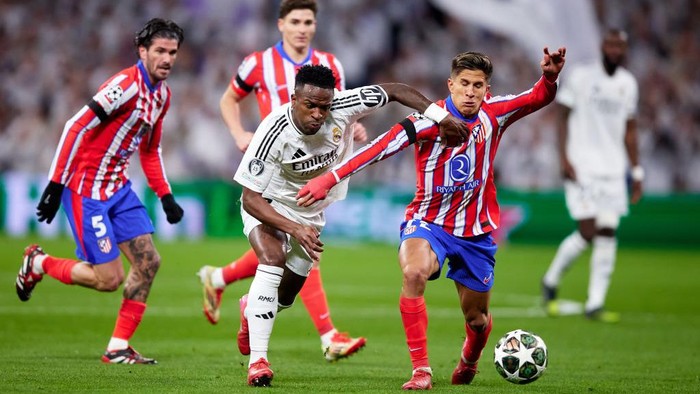 MADRID, SPAIN - MARCH 04: Vinicius Junior of Real Madrid competes for the ball with Giuliano Simeone of Atletico de Madrid during the UEFA Champions League 2024/25 UEFA Champions League 2024/25 Round of 16 first leg match between Real Madrid C.F. and Atletico de Madrid at Santiago Bernanbeu on March 04, 2025 in Madrid, Spain. (Photo by Alvaro Medranda/Quality Sport Images/Getty Images)