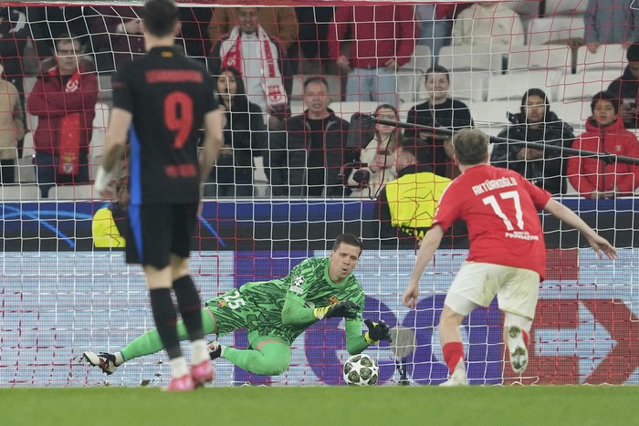 Barcelonas goalkeeper Wojciech Szczesny, center, makes a save during the Champions League round of 16 first leg soccer match between SL Benfica and FC Barcelona at the Luz stadium in Lisbon, Wednesday, March 5, 2025. (AP Photo/Armando Franca)
