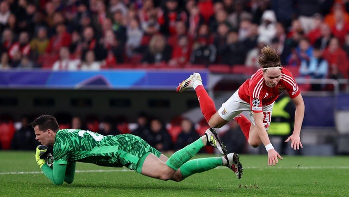 Soccer Football - Champions League - Round of 16 - First Leg - Benfica v FC Barcelona - Estadio da Luz, Lisbon, Portugal - March 5, 2025 FC Barcelonas Wojciech Szczesny in action with Benficas Andreas Schjelderup REUTERS/Rodrigo Antunes
