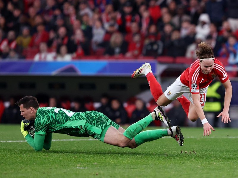 Soccer Football - Champions League - Round of 16 - First Leg - Benfica v FC Barcelona - Estadio da Luz, Lisbon, Portugal - March 5, 2025 FC Barcelona's Wojciech Szczesny in action with Benfica's Andreas Schjelderup REUTERS/Rodrigo Antunes