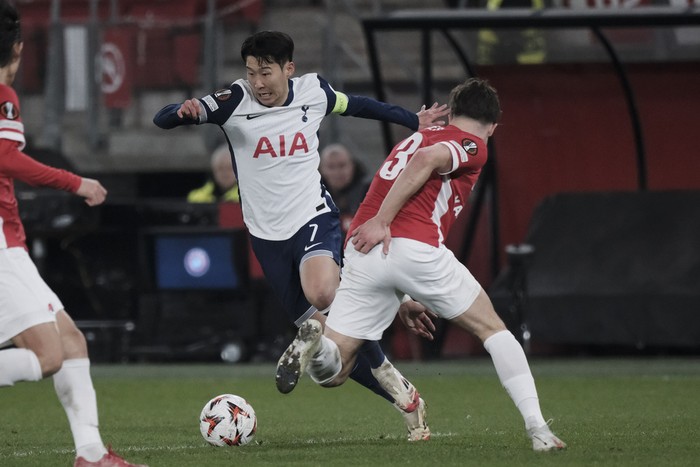 Tottenham's Son Heung-min, left, challenges for the ball with AZ Alkmaar's Wouter Goes during the Europa League round of 16 first leg match between AZ and Tottenham at AFAS Stadium, in Alkmaar, in Alkmaar, Netherlands , Thursday, March 6, 2025. (AP Photo/Patrick Post)