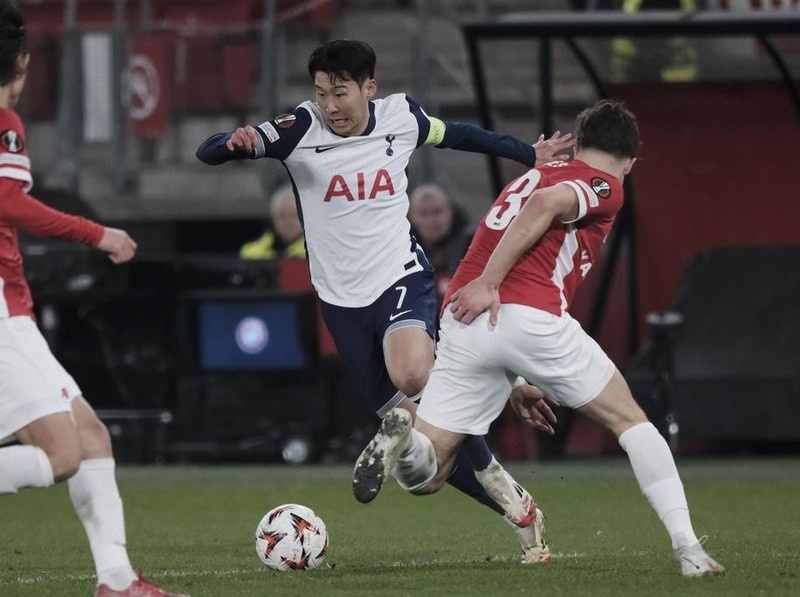 Tottenham's Son Heung-min, left, challenges for the ball with AZ Alkmaar's Wouter Goes during the Europa League round of 16 first leg match between AZ and Tottenham at AFAS Stadium, in Alkmaar, in Alkmaar, Netherlands , Thursday, March 6, 2025. (AP Photo/Patrick Post)