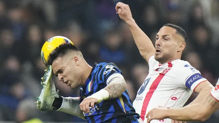 Inter Milans Lautaro Martinez, left, and Monzas Danilo DAmbrosio challenge for the ball during the Serie A soccer match between Inter Milan and Monza at the San Siro stadium in Milan, Italy, Saturday, March 8, 2025. (AP Photo/Luca Bruno)