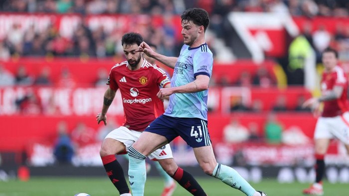 MANCHESTER, ENGLAND - MARCH 09: Declan Rice of Arsenal battles for possession with Bruno Fernandes of Manchester United during the Premier League match between Manchester United FC and Arsenal FC at Old Trafford on March 09, 2025 in Manchester, England. (Photo by Alex Livesey - Danehouse/Getty Images)