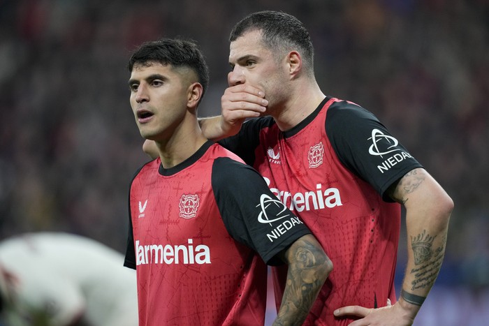 Leverkusens Granit Xhaka, right, speaks with Leverkusens Exequiel Palacios during the Champions League round of 16 second leg soccer match between Bayer Leverkusen and Bayern Munich at the BayArena in Leverkusen, Germany, Tuesday, March 11, 2025. (AP Photo/Martin Meissner)