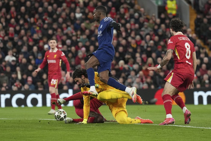 PSGs Ousmane Dembele jumps over Liverpools goalkeeper Alisson to score during the Champions League round of 16 second leg soccer match between Liverpool and Paris Saint-Germain at Anfield in Liverpool, England, Tuesday, March 11, 2025. (AP Photo/Jon Super)