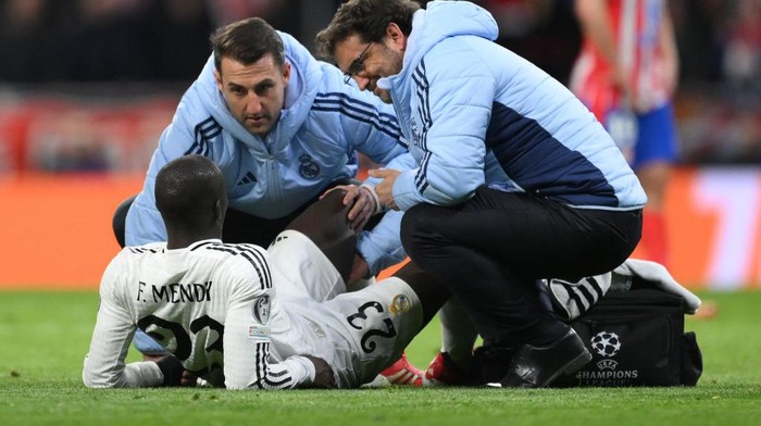 MADRID, SPAIN - MARCH 12: Ferland Mendy of Real Madrid receives medical treatment during the UEFA Champions League 2024/25 Round of 16 second leg match between Atletico de Madrid and Real Madrid C.F. at Estadio Metropolitano on March 12, 2025 in Madrid, Spain. (Photo by David Ramos - UEFA/UEFA via Getty Images)