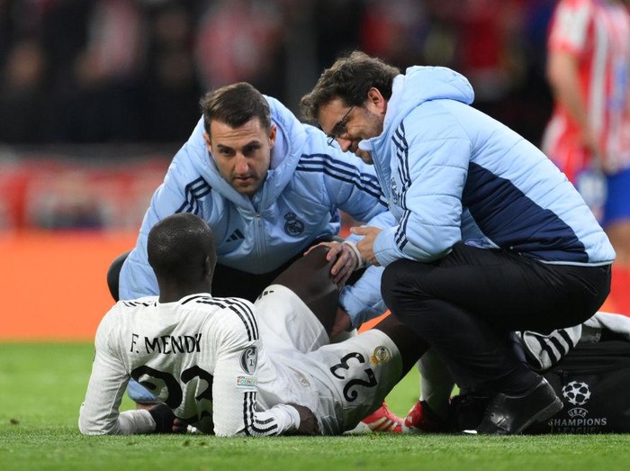 MADRID, SPAIN - MARCH 12: Ferland Mendy of Real Madrid receives medical treatment during the UEFA Champions League 2024/25 Round of 16 second leg match between Atletico de Madrid and Real Madrid C.F. at Estadio Metropolitano on March 12, 2025 in Madrid, Spain. (Photo by David Ramos - UEFA/UEFA via Getty Images)