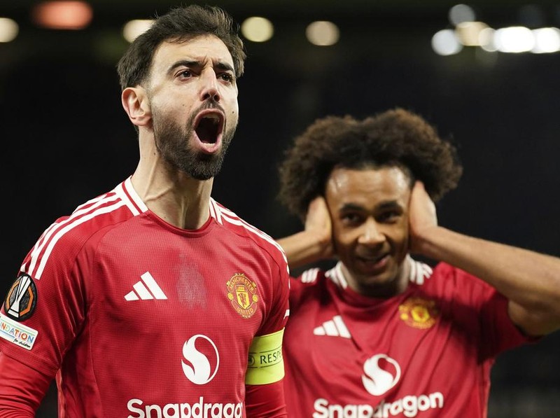 Manchester United's Bruno Fernandes left, and Manchester United's Joshua Zirkzee celebrate scoring their side's first goal during the Europa League soccer match between Manchester United and Real Sociedad at Old Trafford stadium in Manchester, England, Thursday, March 13, 2025 . (AP Photo/Dave Thompson)
