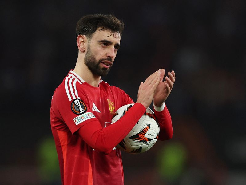 Soccer Football - Europa League - Round of 16 - Second Leg - Manchester United v Real Sociedad - Old Trafford, Manchester, Britain - March 13, 2025  Manchester United's Bruno Fernandes celebrates with the match ball after the match after scoring a hat-trick REUTERS/Phil Noble