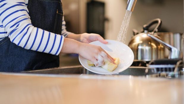 Waitress washing dish in the kitchen of restaurant