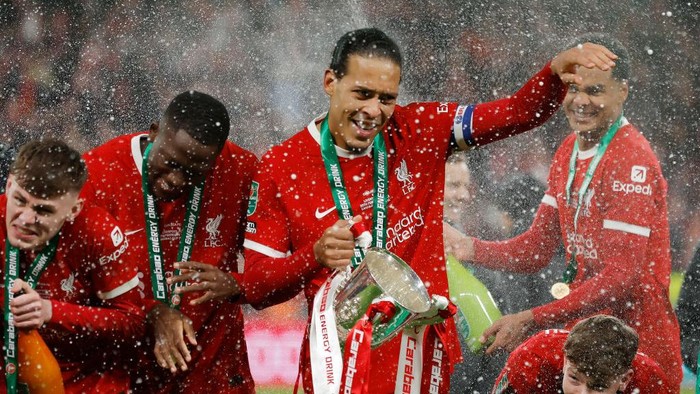 Liverpool captain Virgil Van Dijk with the trophy next to Bradley, Konate and McConnell after the EFL Carabao Cup Final between Chelsea and Liverpool at Wembley Stadium on February 25th 2024 in London, England (Photo by Tom Jenkins/Getty Images)