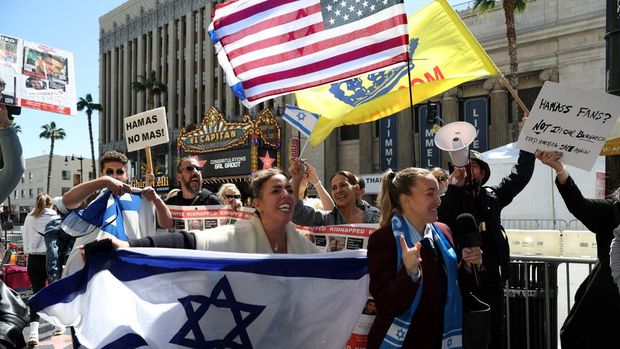 Pro-Israel and pro-Palestinian people protest in front of the El Capitan Theater during Israeli actress Gal Gadot's Hollywood Walk of Fame Star Ceremony in Los Angeles, California, on March 18, 2025. (Photo by VALERIE MACON / AFP)