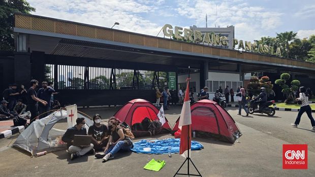 Sejumlah massa aksi tolak RUU TNI memasang tenda dan bermalam di depan Gerbang Pancasila, Kompleks Parlemen, Jakarta, 20 Maret 2025. Gerbang itu merupakan salah satu akses mobil anggota DPR. (CNNIndonesia/Taufiq Hidayatullah)