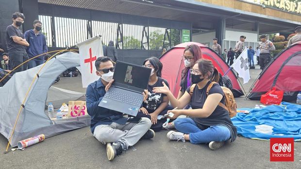 Sejumlah massa aksi tolak RUU TNI memasang tenda dan bermalam di depan Gerbang Pancasila, Kompleks Parlemen, Jakarta, 20 Maret 2025. Gerbang itu merupakan salah satu akses mobil anggota DPR. (CNNIndonesia/Taufiq Hidayatullah)