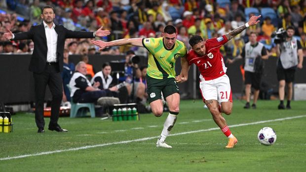 Australia's Lewis Miller (L) vies for the ball with Indonesia's Dean James during their World Cup 2026 Asian qualifier football match between Australia and Indonesia in Sydney on March 20, 2025. (Photo by Saeed KHAN / AFP) / -- IMAGE RESTRICTED TO EDITORIAL USE - STRICTLY NO COMMERCIAL USE --