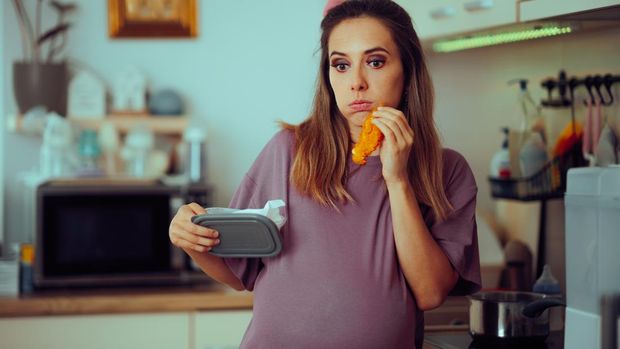Hungry mother to be eating meat for to fight iron deficiency and anemia