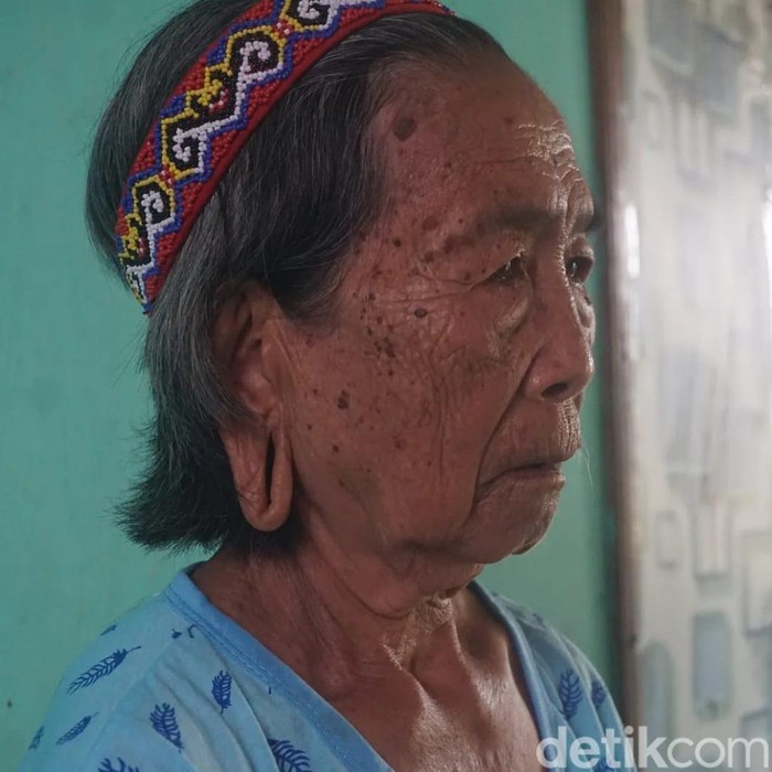 Tato dan Telinga Panjang Tanda Bangsawan Di Desa Sungai Urang, Kabupaten Bulungan, Kalimantan Utara, suatu rumah susila berdiri sederhana di tepi jalanan berbatu. Di samping bangunan tersebut, Lem Dungau, seorang nenek duduk dengan tenang.