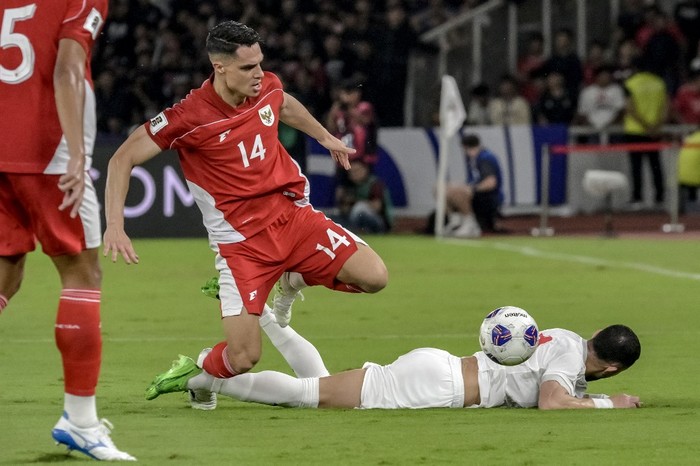 FBL-WC-2026-ASIA-INA-BHR Indonesias Joey Pelupessy (C) fights for the ball with Bahrains Mahdi Humaidan (R) during the World Cup 2026 Asian qualifier football match between Indonesia and Bahrain at Bung Karno Stadium in Jakarta on March 25, 2025. (Photo by Bay ISMOYO / AFP)