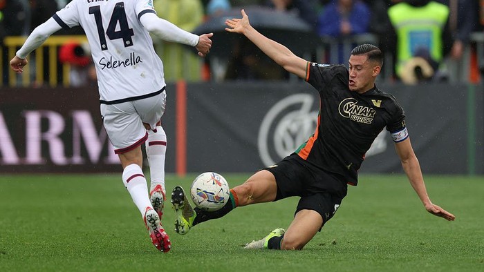 VENICE, ITALY - MARCH 29: Jay Idzes of Venezia tackles Davide Calabria of Bologna during the Serie A match between Venezia and Bologna at Stadio Pier Luigi Penzo on March 29, 2025 in Venice, Italy. (Photo by Timothy Rogers/Getty Images)