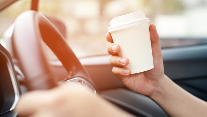 1754004169 people person business man drinking paper cup coffee of hot in hand while driving in a car in the Morning sunlight .transportation and vehicle concept.