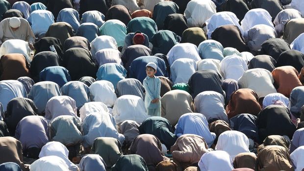 A Muslim boy stands amidst men as they attend Eid al-Fitr prayers to mark the end of the holy month of Ramadan, in Karachi, Pakistan March 31, 2025. REUTERS/Akhtar Soomro