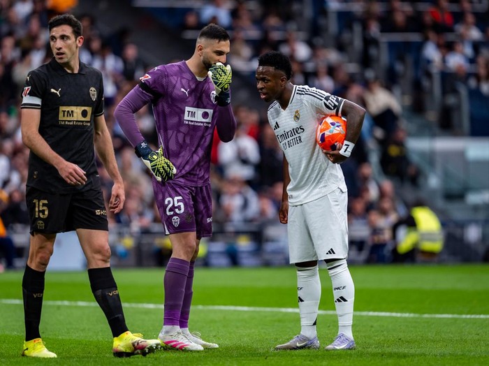 Giorgi Mamardashvili of Valencia CF speaks with Vinicius Junior of Real Madrid CF during the La Liga EA Sports 2024/25 football match between Real Madrid CF and Valencia CF at Estadio Santiago Bernabeu in Madrid, Spain, on April 5, 2025. (Photo by Alberto Gardin/NurPhoto via Getty Images)