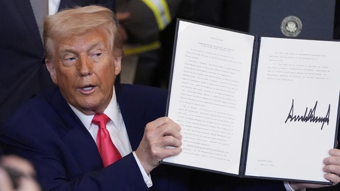 President Donald Trump holds a signed an executive order during an event in the East Room of the White House, Tuesday, April 8, 2025, in Washington. (AP Photo/Alex Brandon)
