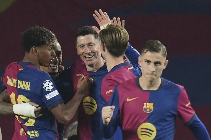 Barcelonas Robert Lewandowski, center, celebrates after scoring his sides second goal during the Champions League quarterfinal first leg soccer match between Barcelona and Borussia Dortmund, at the Lluis Companys Olympic stadium in Barcelona, Spain, Wednesday, April 9, 2025. (AP Photo/Emilio Morenatti)