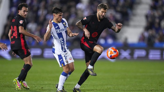 Barcelonas Inigo Martinez, right, and Leganes Adria Altimira challenge for the ball during the Spanish La Liga soccer match between CD Leganes and Barcelona at the Butarque stadium in Leganes, outside Madrid, Spain, Saturday, April 12, 2025. (AP Photo/Manu Fernandez)