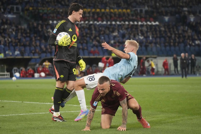Romas goalkeeper Mile Svilar, left, and Lazios Gustav Isaksen during the Italian Serie A soccer match between Lazio and Roma at Romes Olympic stadium, Sunday, April 13, 2025. (AP Photo/Gregorio Borgia)