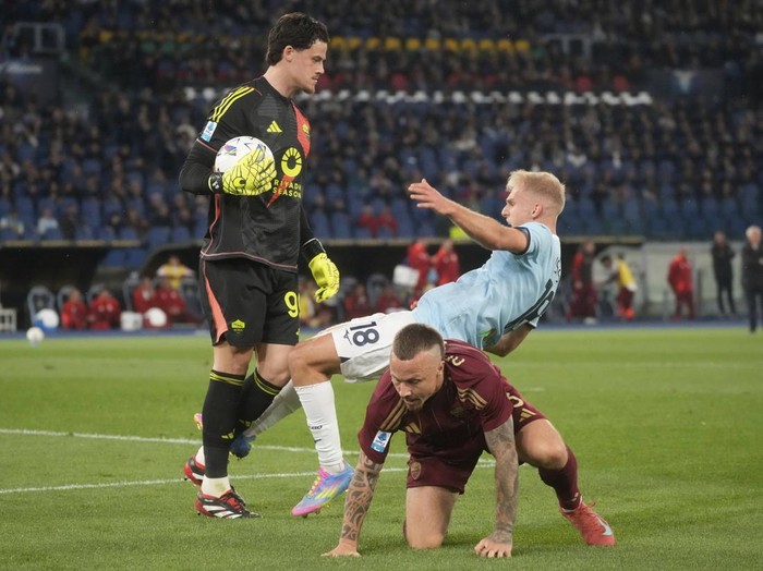 Roma's goalkeeper Mile Svilar, left, and Lazio's Gustav Isaksen during the Italian Serie A soccer match between Lazio and Roma at Rome's Olympic stadium, Sunday, April 13, 2025. (AP Photo/Gregorio Borgia)