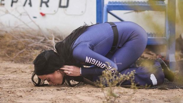 Foto selebaran dari Blue Origin ini memperlihatkan penyanyi AS Katy Perry mencium tanah saat kembali ke Bumi setelah penerbangan dengan Blue Origin New Shepard NS-31, yang membawa penumpang melewati garis Karman -- batas ruang angkasa yang diakui secara internasional, di Van Horn, Texas Barat, 14 April 2025. (Photo by Handout / BLUE ORIGIN / AFP)