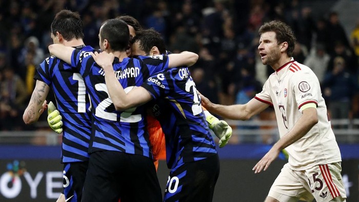 Soccer Football - Champions League - Quarter Final - Second Leg - Inter Milan v Bayern Munich - San Siro, Milan, Italy - April 16, 2025 Inter Milan players celebrate after the match as Bayern Munichs Thomas Muller looks dejected REUTERS/Alessandro Garofalo