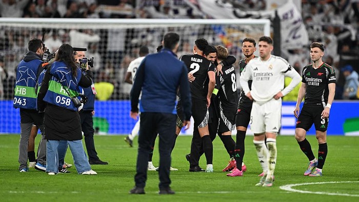 MADRID, SPAIN - APRIL 16: Mikel Arteta, Manager of Arsenal, celebrates victory with William Saliba and Martin Odegaard following the UEFA Champions League 2024/25 Quarter Final Second Leg match between Real Madrid C.F. and Arsenal FC at Estadio Santiago Bernabeu on April 16, 2025 in Madrid, Spain. (Photo by David Price/Arsenal FC via Getty Images)