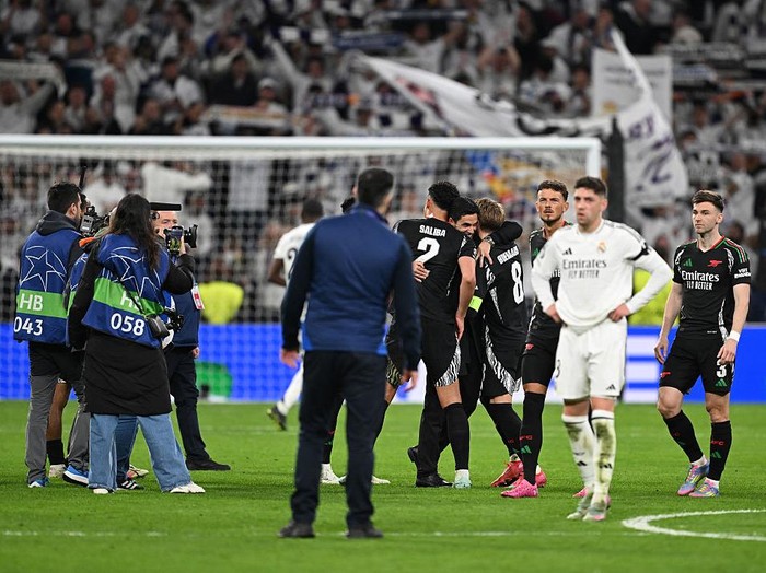 MADRID, SPAIN - APRIL 16: Mikel Arteta, Manager of Arsenal, celebrates victory with William Saliba and Martin Odegaard following the UEFA Champions League 2024/25 Quarter Final Second Leg match between Real Madrid C.F. and Arsenal FC at Estadio Santiago Bernabeu on April 16, 2025 in Madrid, Spain. (Photo by David Price/Arsenal FC via Getty Images)