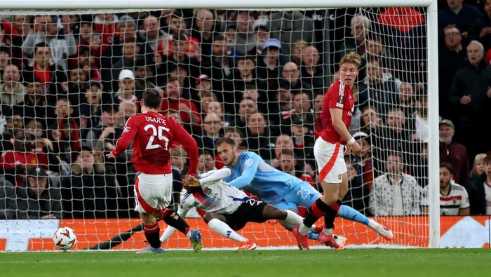MANCHESTER, ENGLAND - APRIL 17: Manuel Ugarte of Manchester United scores his teams first goal under pressure from Clinton Mata of Olympique Lyonnais past Lucas Perri of Olympique Lyonnais during the UEFA Europa League 2024/25 Quarter Final Second Leg match between Manchester United and Olympique Lyonnais at Old Trafford on April 17, 2025 in Manchester, England. (Photo by Carl Recine/Getty Images)