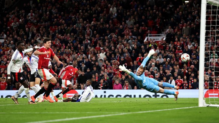 MANCHESTER, ENGLAND - APRIL 17: Kobbie Mainoo of Manchester United scores his teams fourth goal past Lucas Perri of Olympique Lyonnais during the UEFA Europa League 2024/25 Quarter Final Second Leg match between Manchester United and Olympique Lyonnais at Old Trafford on April 17, 2025 in Manchester, England. (Photo by Carl Recine/Getty Images)