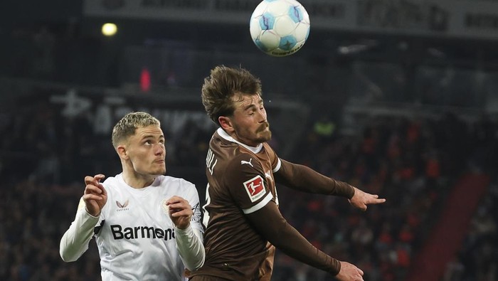 20 April 2025, Hamburg: Soccer: Bundesliga, FC St. Pauli - Bayer Leverkusen, Matchday 30, Millerntor-Stadion, St. Paulis Connor Metcalfe (r) and Leverkusens Florian Wirtz fighting for the ball. Photo: Christian Charisius/dpa - IMPORTANT NOTE: In accordance with the regulations of the DFL German Football League and the DFB German Football Association, it is prohibited to utilize or have utilized photographs taken in the stadium and/or of the match in the form of sequential images and/or video-like photo series. (Photo by Christian Charisius/picture alliance via Getty Images)