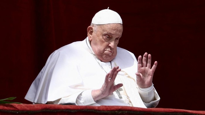Pope Francis gestures from a balcony as the 