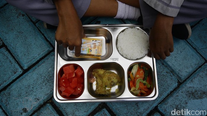 Murid SD menerima dan memakan santapan makan bergizi gratis di SDN Jurang Mangu Timur 02, Tangerang Selatan, Banten, Selasa (25/4/2025).