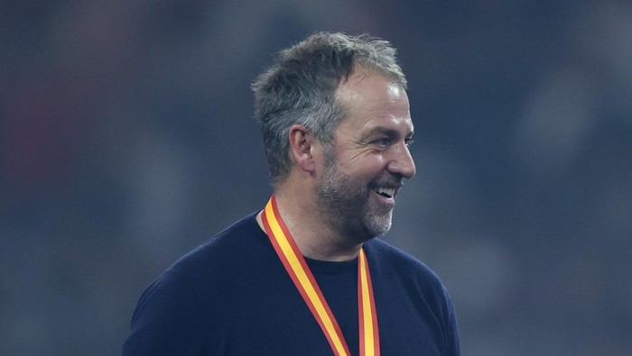 JEDDAH, SAUDI ARABIA - JANUARY 12: Hansi Flick, Head Coach of FC Barcelona, reacts whilst wearing his Supercopa de Espana winners medal during the trophy presentation after the Spanish Super Cup Final between Real Madrid and FC Barcelona at King Abdullah Sports City on January 12, 2025 in Jeddah, Saudi Arabia. (Photo by Yasser Bakhsh/Getty Images)