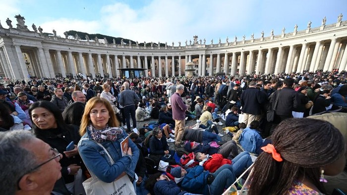 Attendees arrive at St Peters Square with the colonnade in the background ahead of late Pope Francis funeral in the Vatican on April 26, 2025. Pope Francis, champion of the poor and the Churchs first Latin American leader, will be honoured April 26 with a funeral attended by world leaders and tens of thousands of Catholic faithful. The Argentine pontiff, who died on April 21, 2025, aged 88, sought to create a more open-minded Church during his 12-year papacy, and many emotional tributes have been made -- with 250,000 people paying respects at his coffin in St Peters Basilica. (Photo by Andreas SOLARO / AFP)